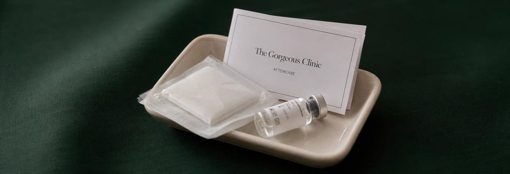 Photorealistic still life of an aftercare kit: a small cream ceramic tray with sterile gauze, an unopened vial, and a printed aftercare leaflet folded so text is unreadable, forest green cloth background, soft editorial light, single focal point.